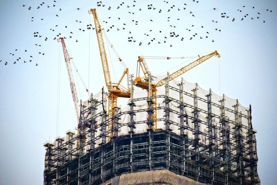 Torre en construcción rodeada de grúas y andamios
